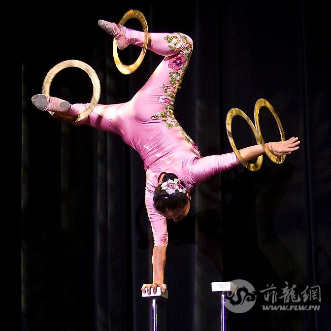 acrobat-li-liu-balances-single-handed-on-a-beam-while-spinning-rings-with-arms-a.jpg